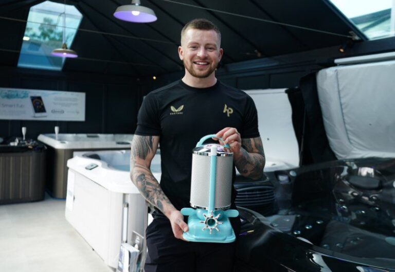 Jacuzzi® brand ambassador demonstrating advanced water wellness technology in a luxury hot tub showroom