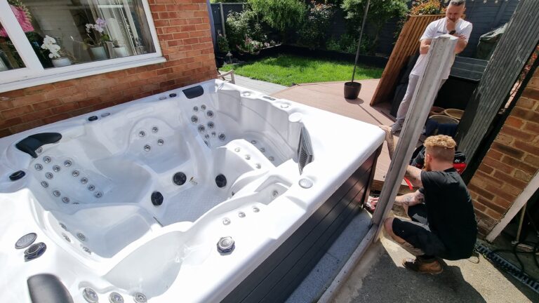Spa Wars team assessing tight garden access for a white Jacuzzi hot tub delivery.